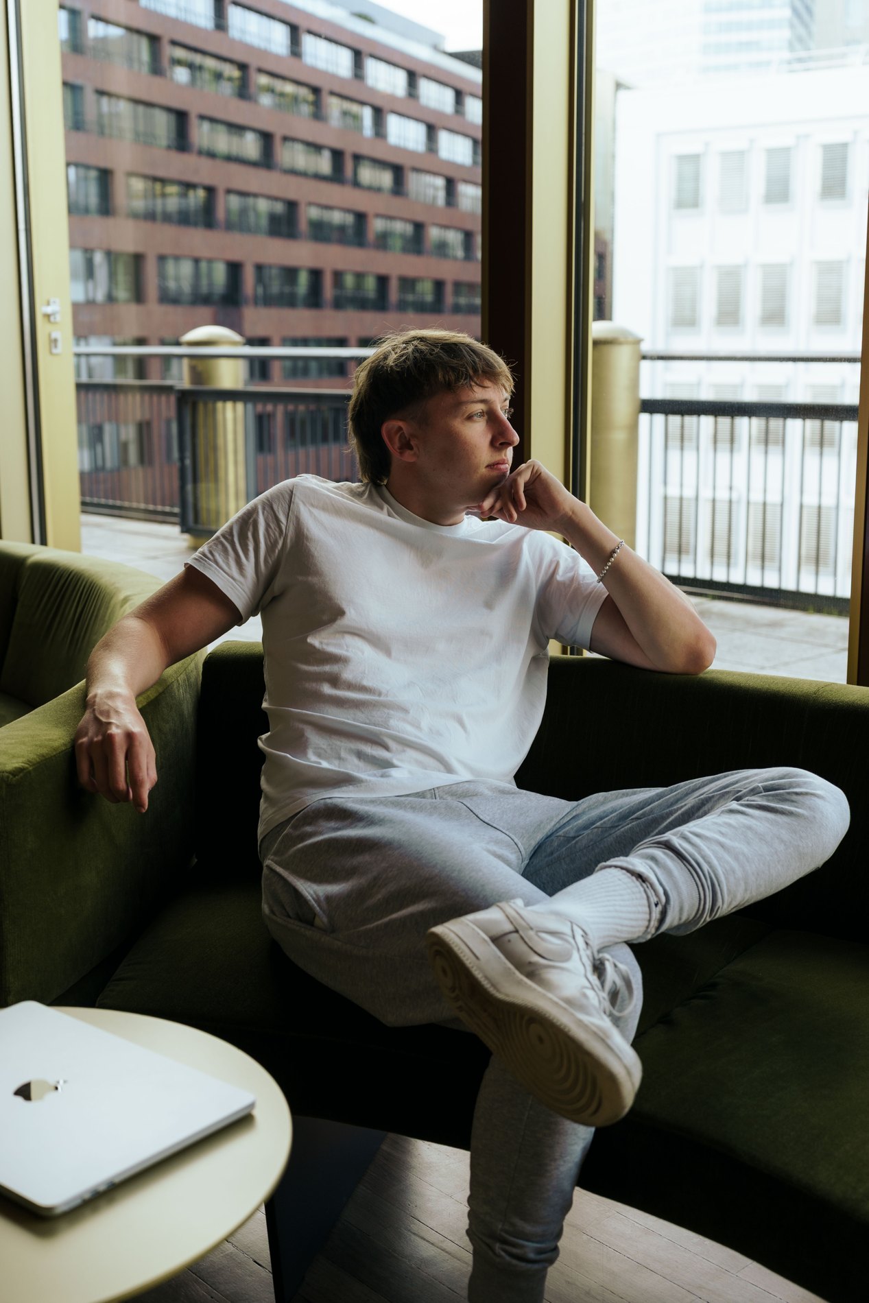 Alex Frieling sitting on a sofa, looking into the distance